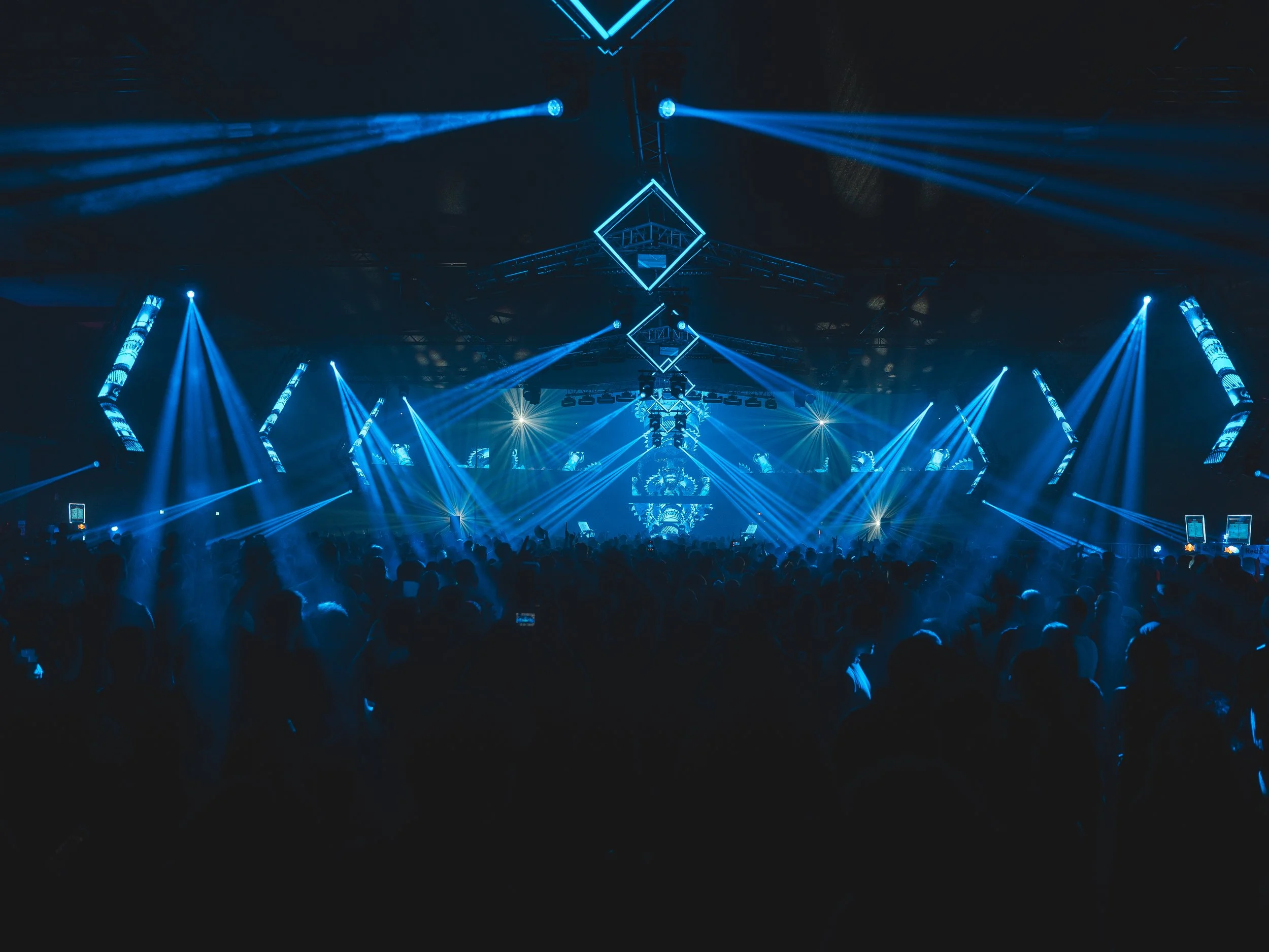 Bühne mit blauer Lichtshow und Zuschauer bei einem Konzert oder Event.