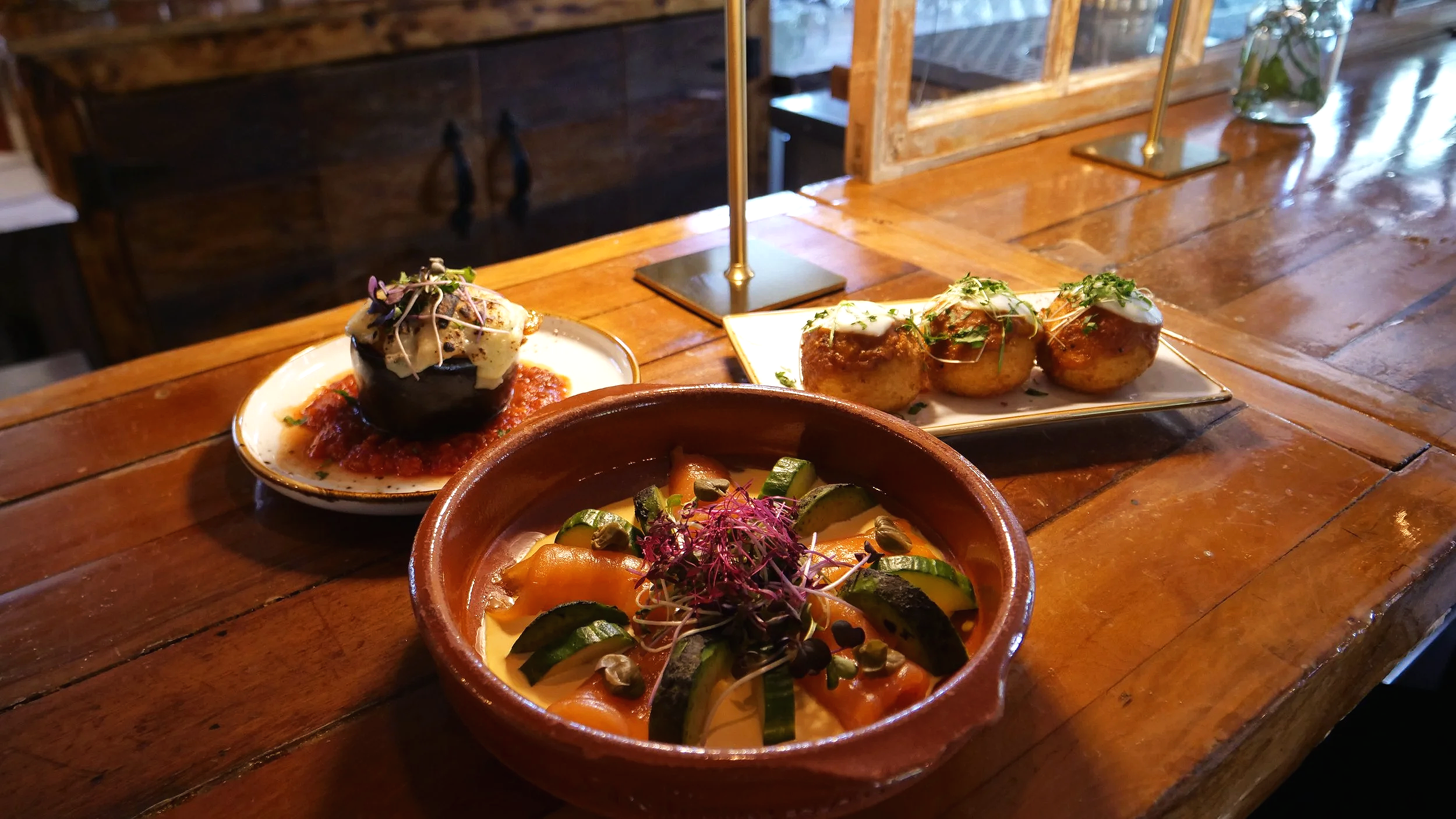 Assortiment de plats mexicains traditionnels, comprenant des tacos, des légumes et d'autres mets présentés sur un plateau en bois.