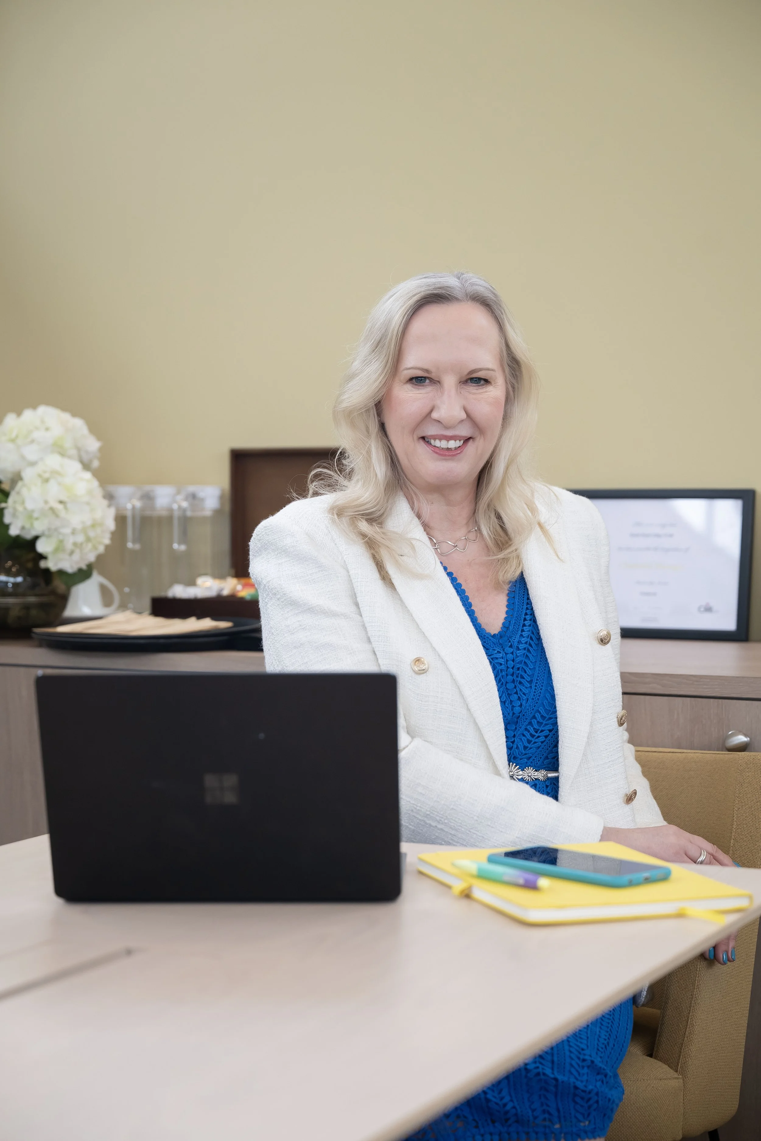 a woamn sat at her desk in front of her laptop