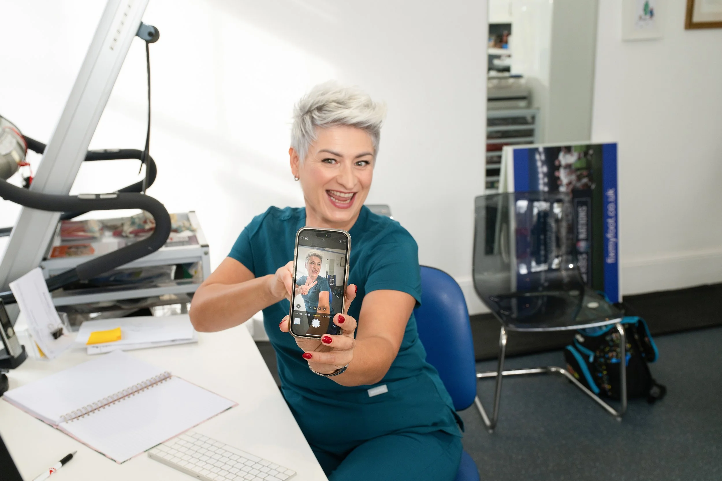 a foot practitioner with her mobile phone