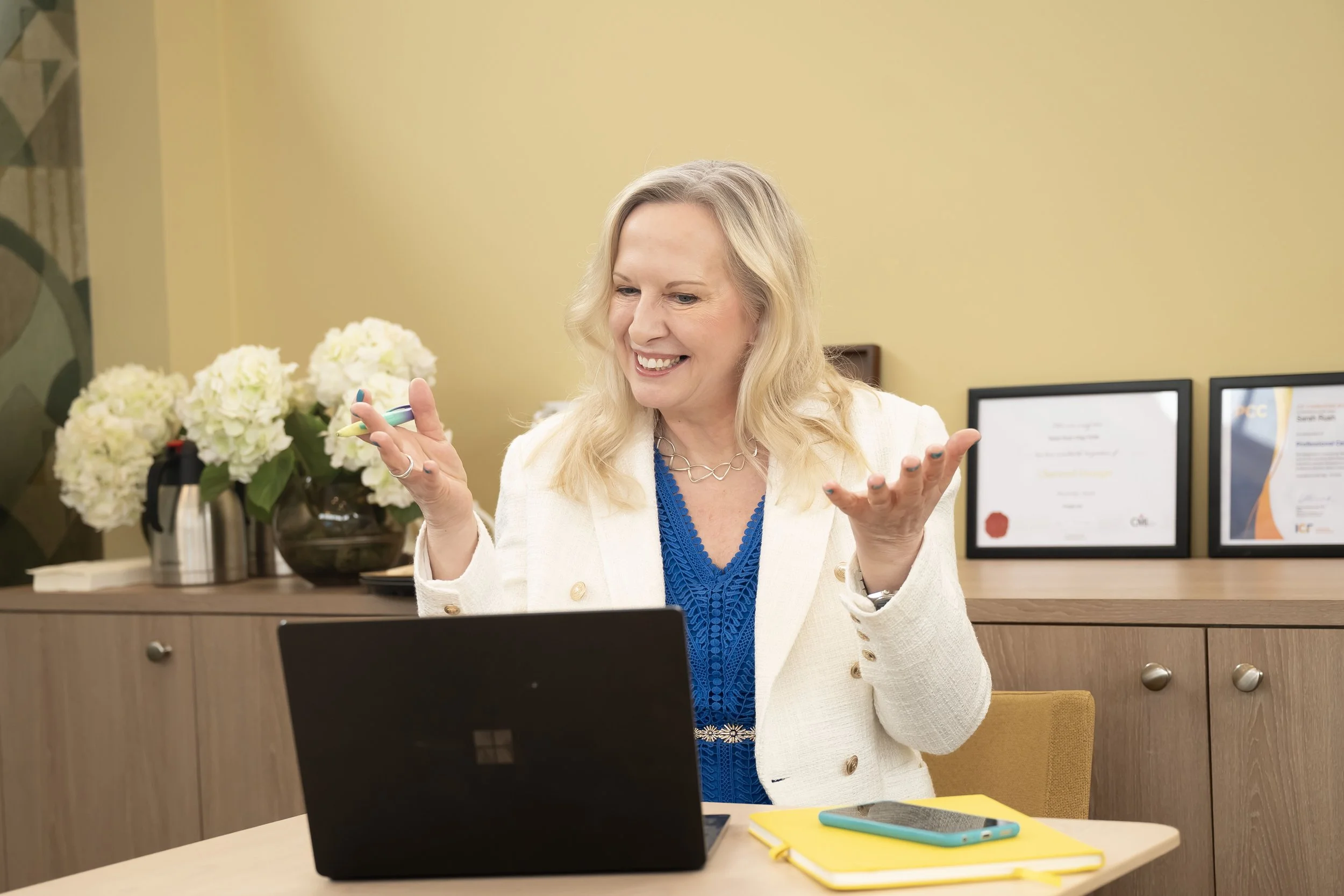 a woman speaking to a client on her laptop