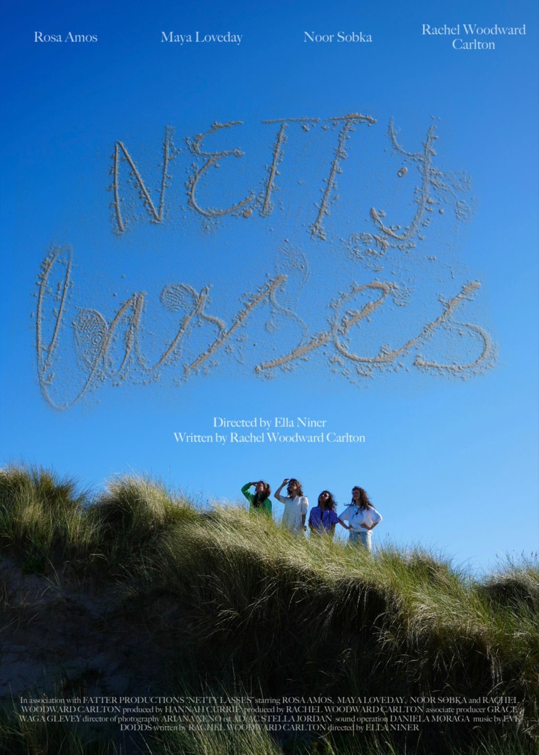 Movie poster for 'Née' showing four women standing on a grassy dune with a blue sky background. The title is written in the sand at the top, and the cast and crew information is at the bottom.