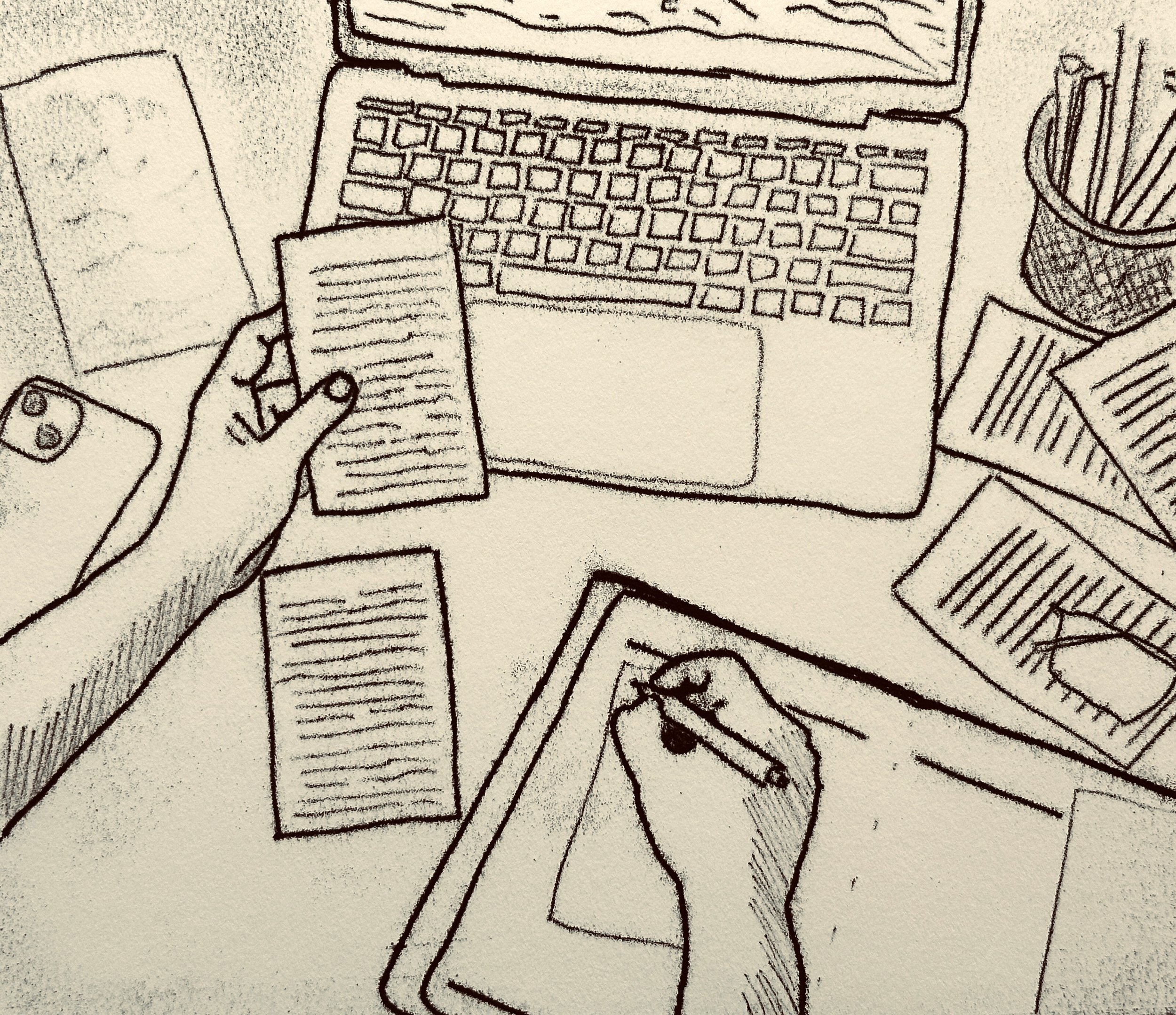 A scene of productivity that includes a phone, laptop, pens, notepads, and a hand that is writing in an open notebook.