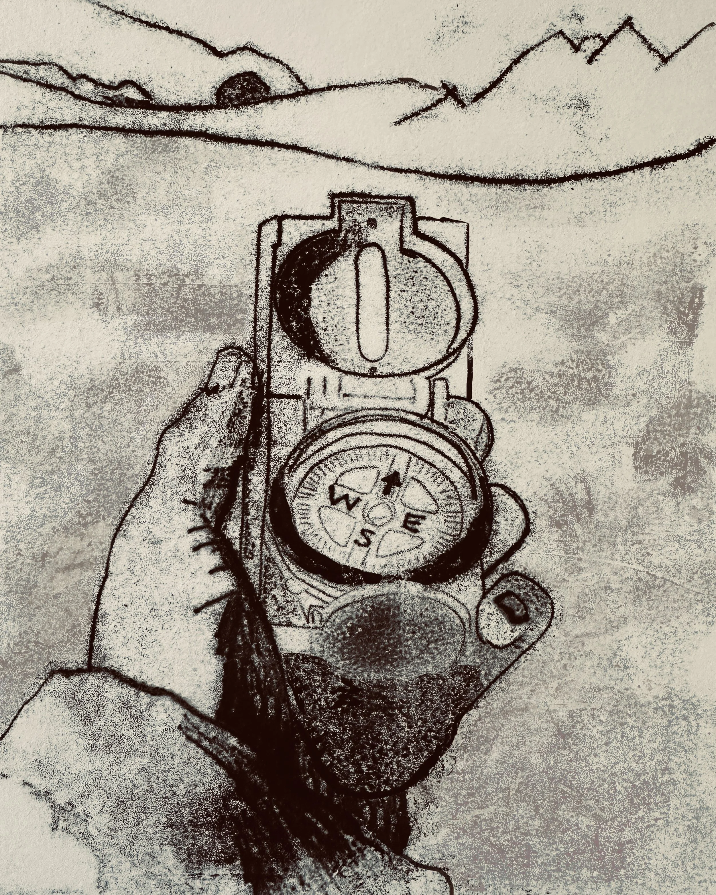A hand holds a compass pointing north. There are hills and mountains in the distance.