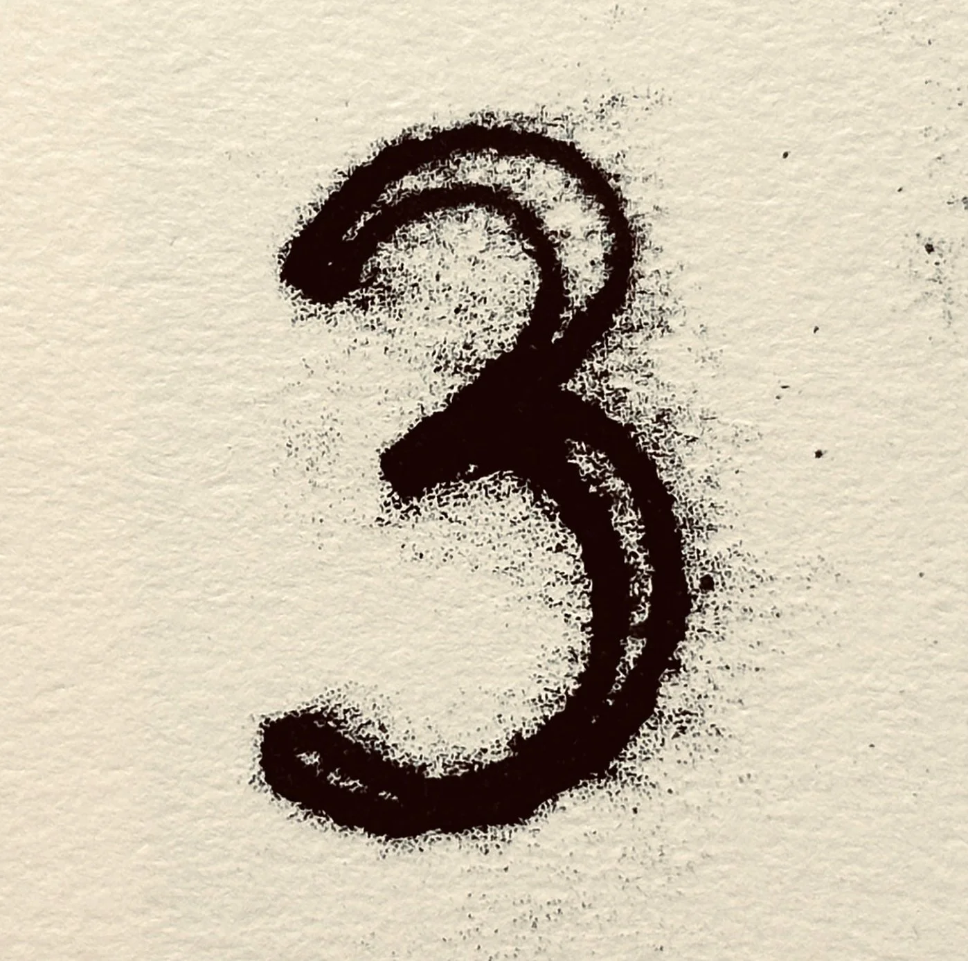 Black spray-painted question mark on textured beige paper.