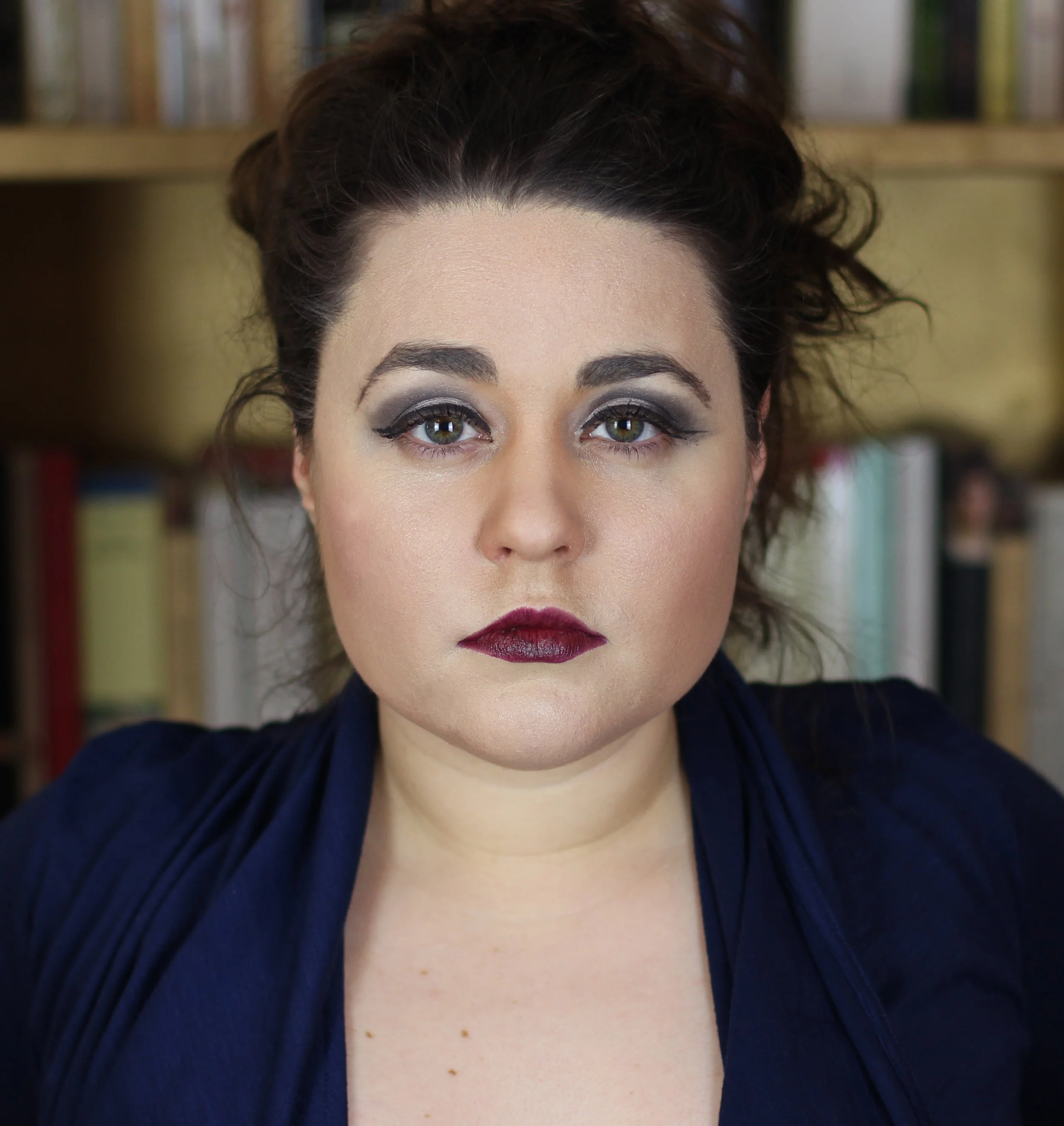 Close-up portrait of Roslyn Fuller with dark hair, green eyes, smoky eye makeup, and burgundy lipstick
