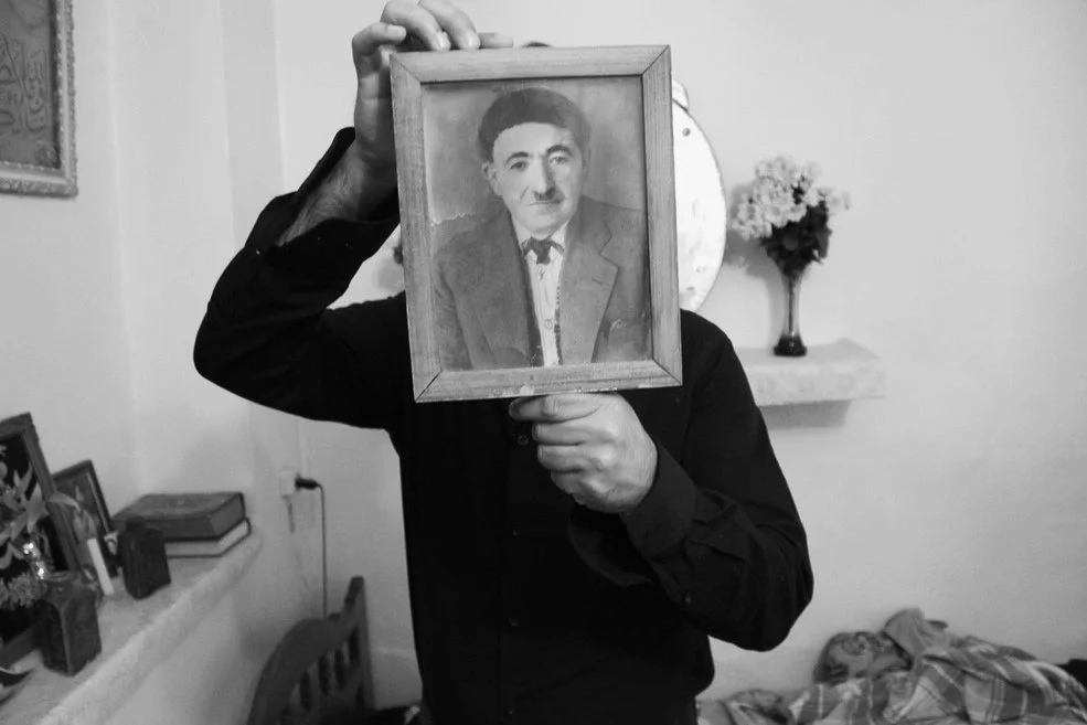 Every portrait survives by borrowing another face. The living hand lifts the image of the dead, but in doing so, the boundary between remembrance and identity begins to dissolve. Presence is no longer located in a body, nor in a photograph, but in th