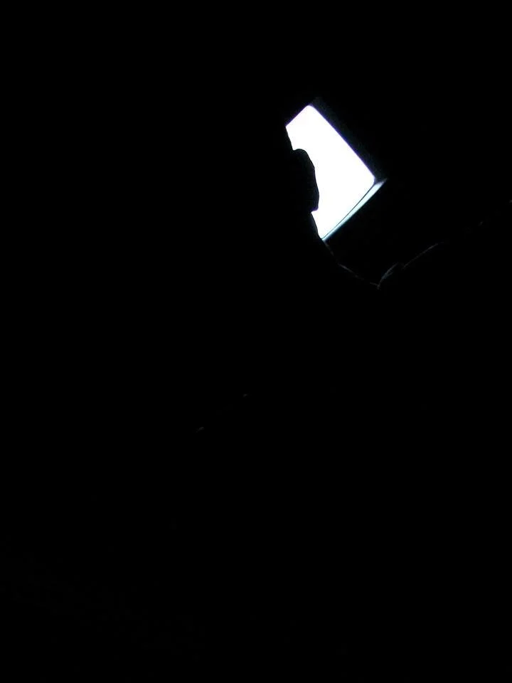 Darkness is not the absence of light; it is the place where light becomes visible. The solitary rectangle does not promise revelation but distance, drawing the eye toward something that forever remains beyond reach. The human figure survives only as 
