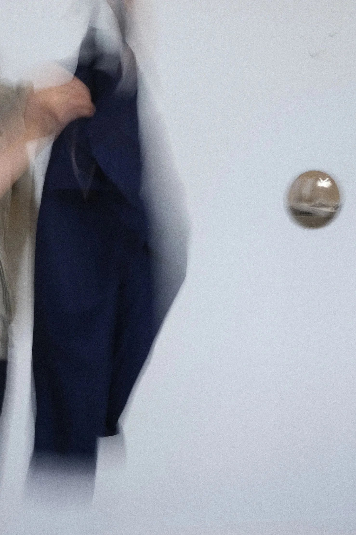 Vêtements suspendus dans un placard contre un mur blanc.