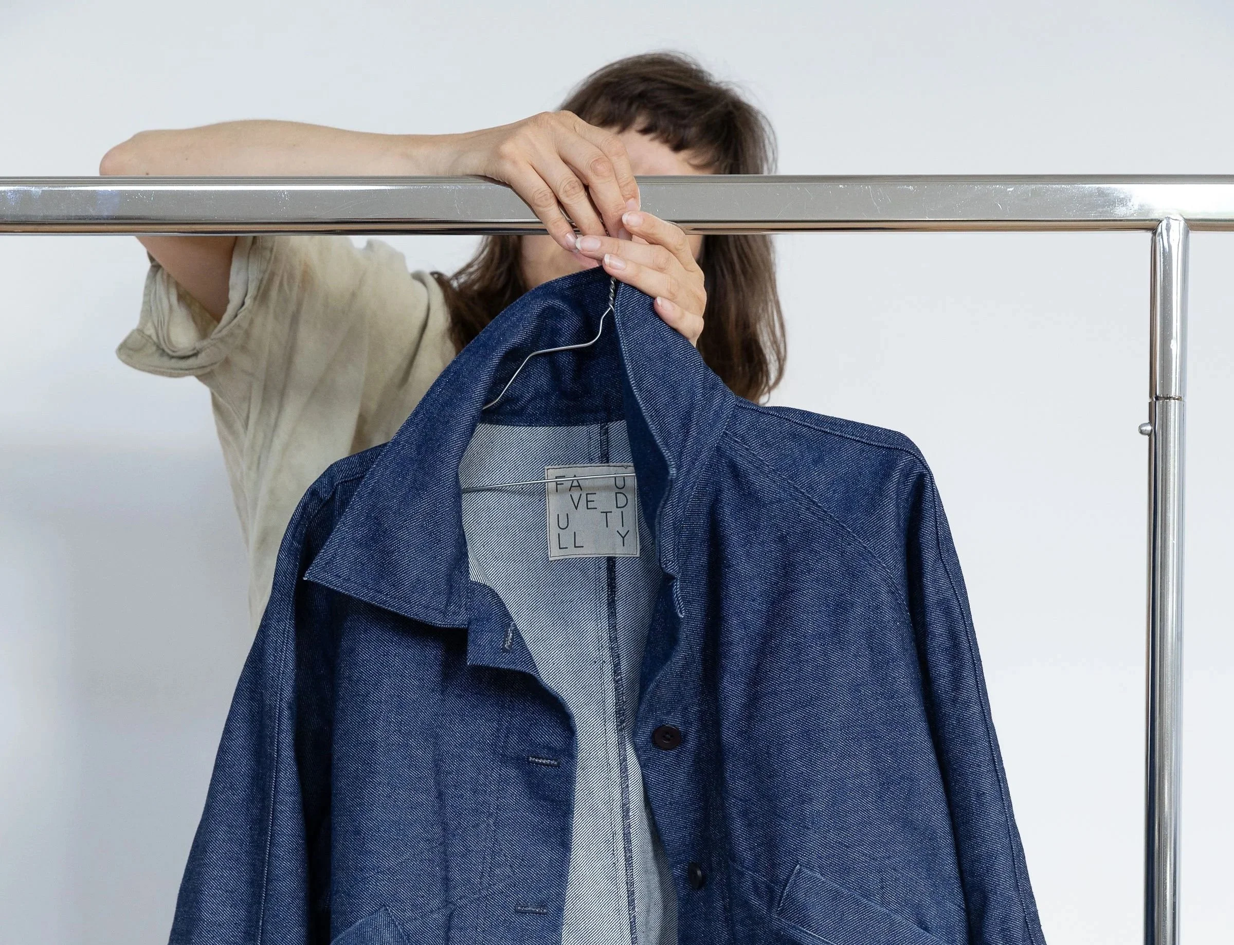 Femme suspendue à une barre en train de coudre un vêtement en denim