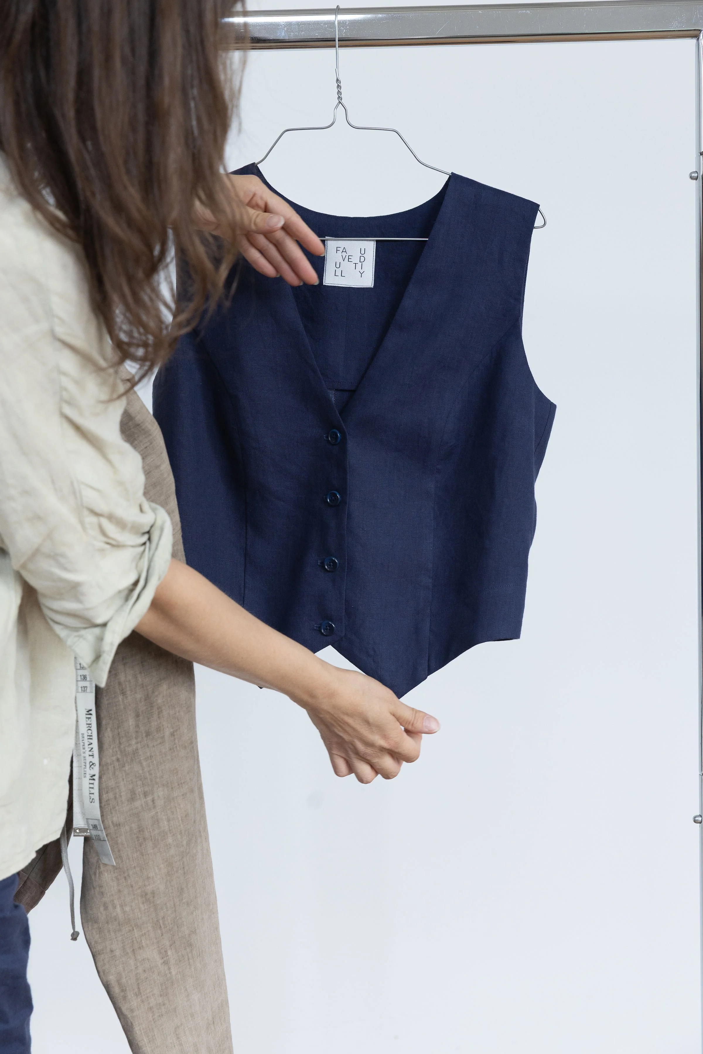Une personne montre une robe en denim pour essayer ou exhiber dans une cabine d'essayage.
