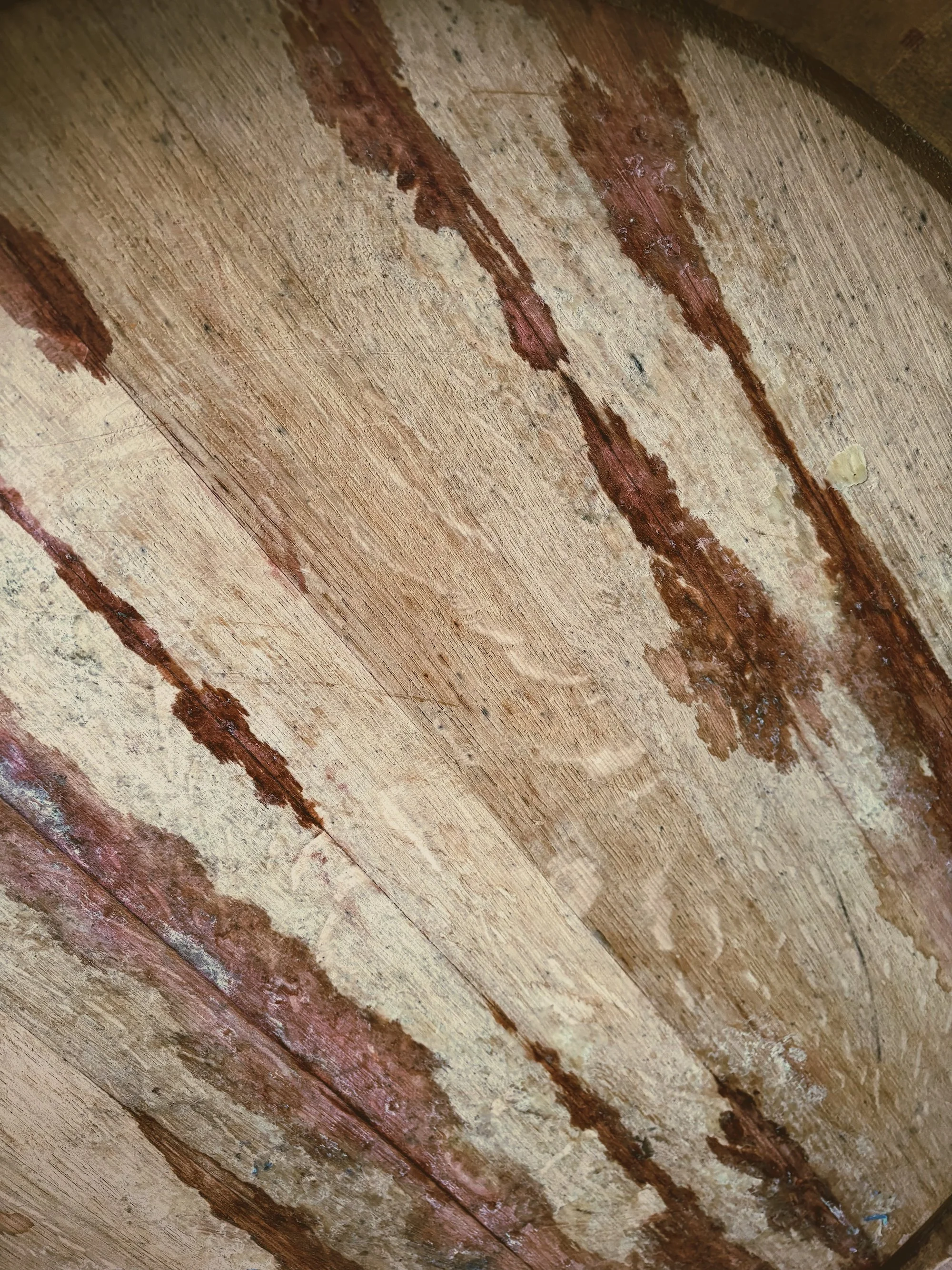 Close-up of a wooden surface with rusty metal streaks and discoloration.