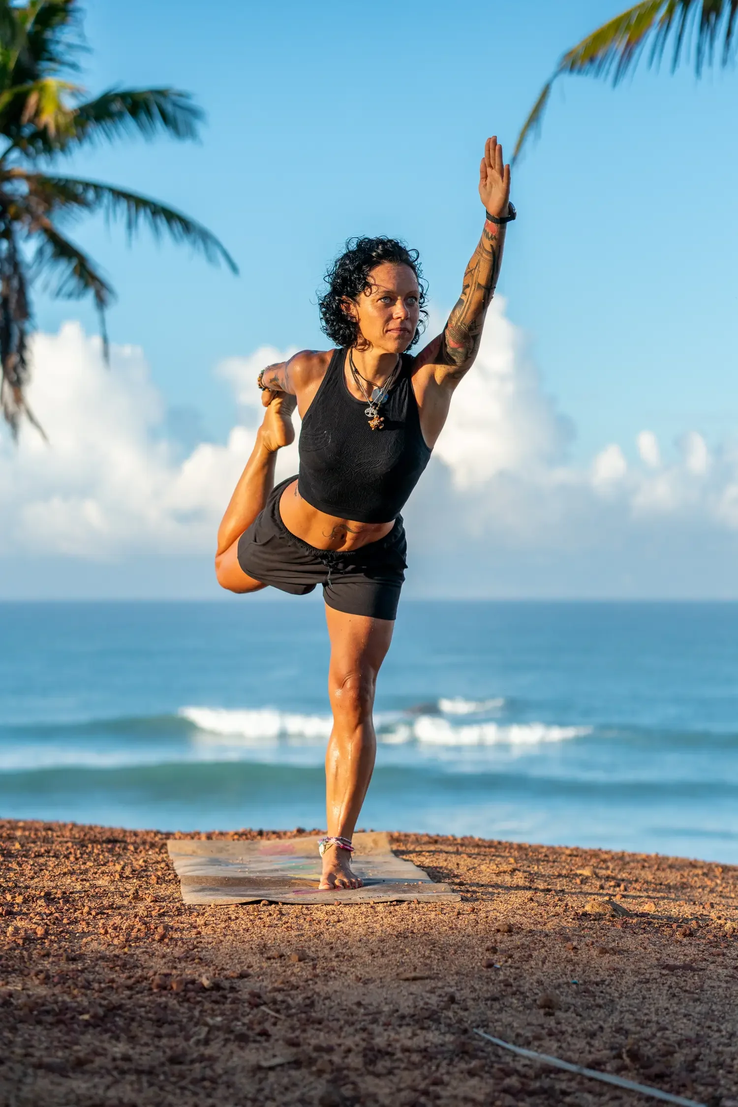 Caro in Natarajasana dancer's pose balancing in green forest retreat