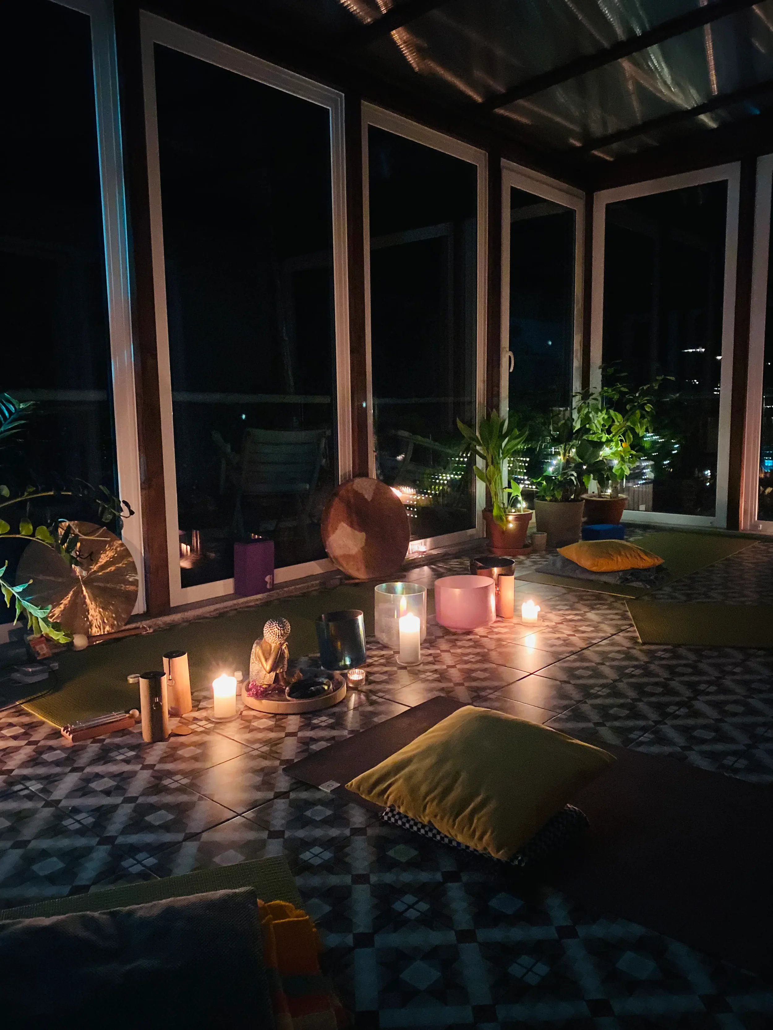 Candlelit sound healing and Yin Yoga setup with singing bowls and meditation mats at a winter retreat in Brandenburg near Berlin.
