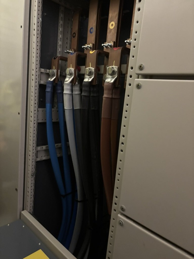 Color-coded electrical cables organized inside an electrical panel or server rack.