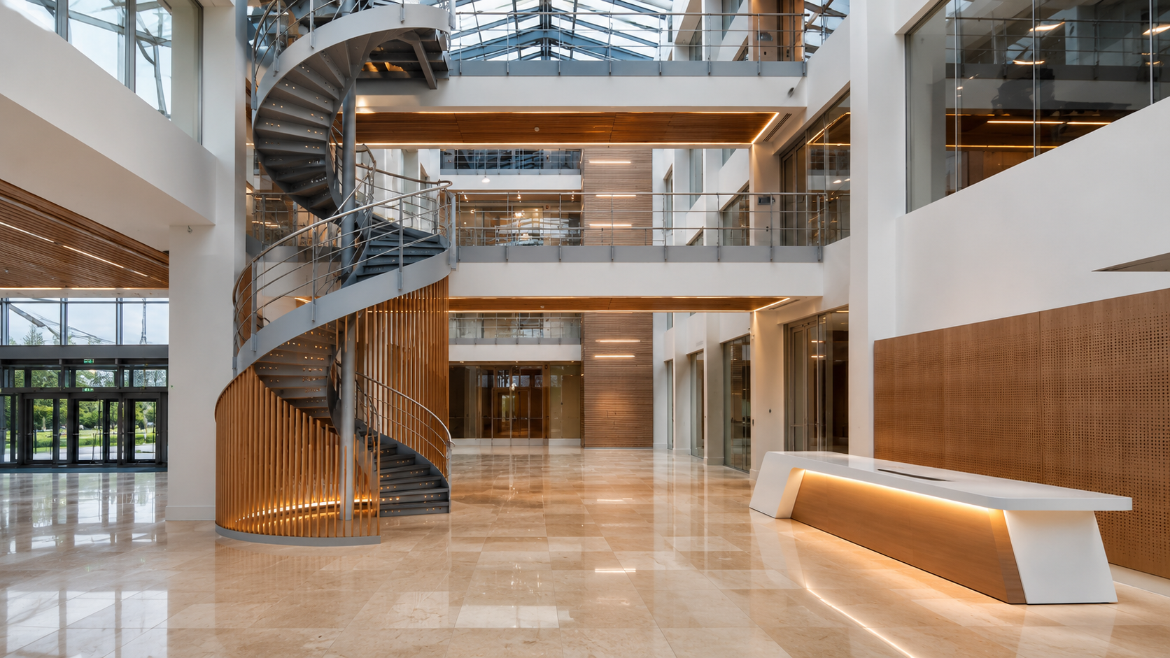 Contemporary multi-storey commercial atrium with spiral staircase, illustrating complex fit-out, refurbishment and project delivery experience.