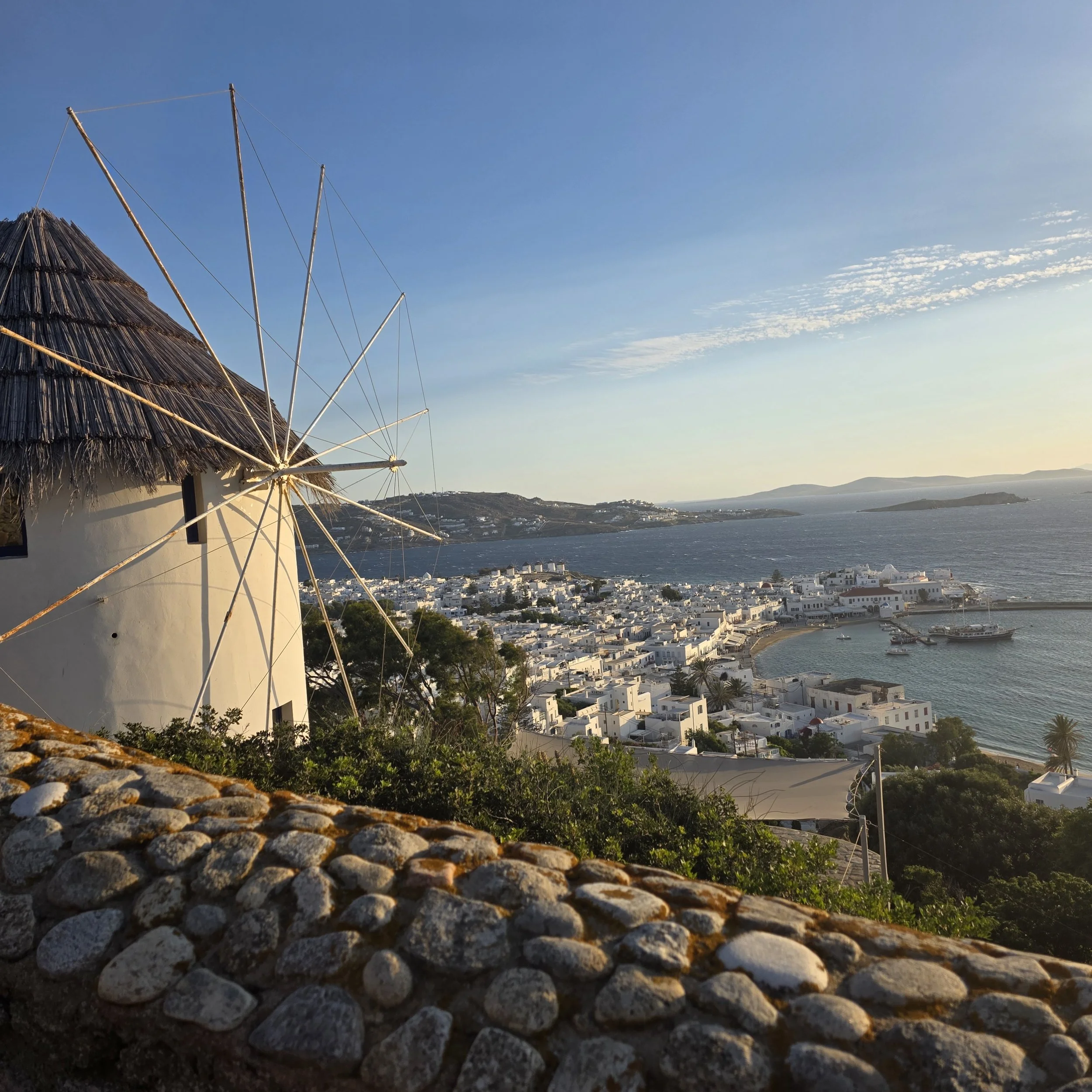Iconic windmills and blue-domed buildings in Mykonos, Greece