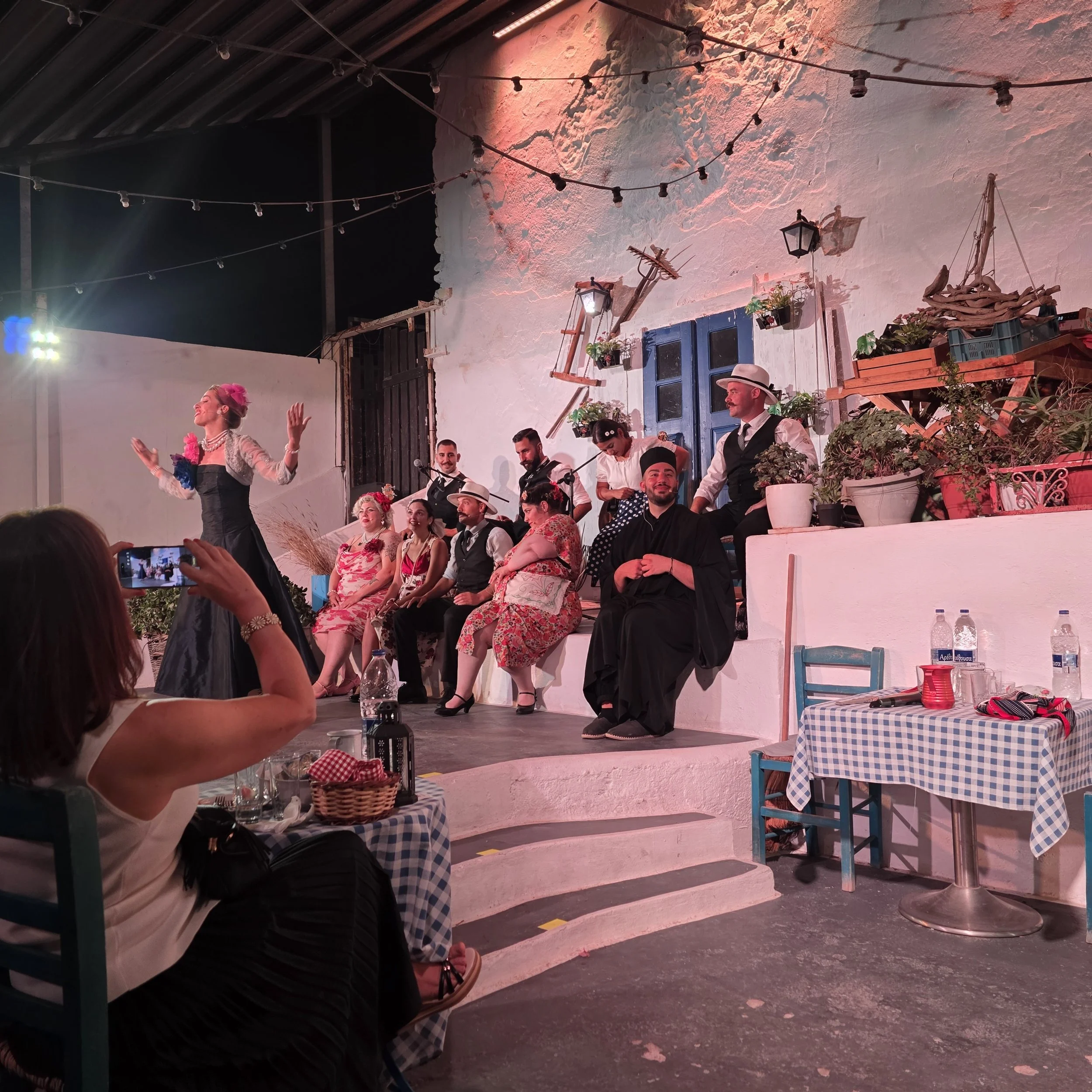 Performers in traditional Greek costumes singing and dancing at the Greek Wedding Show in Santorini.