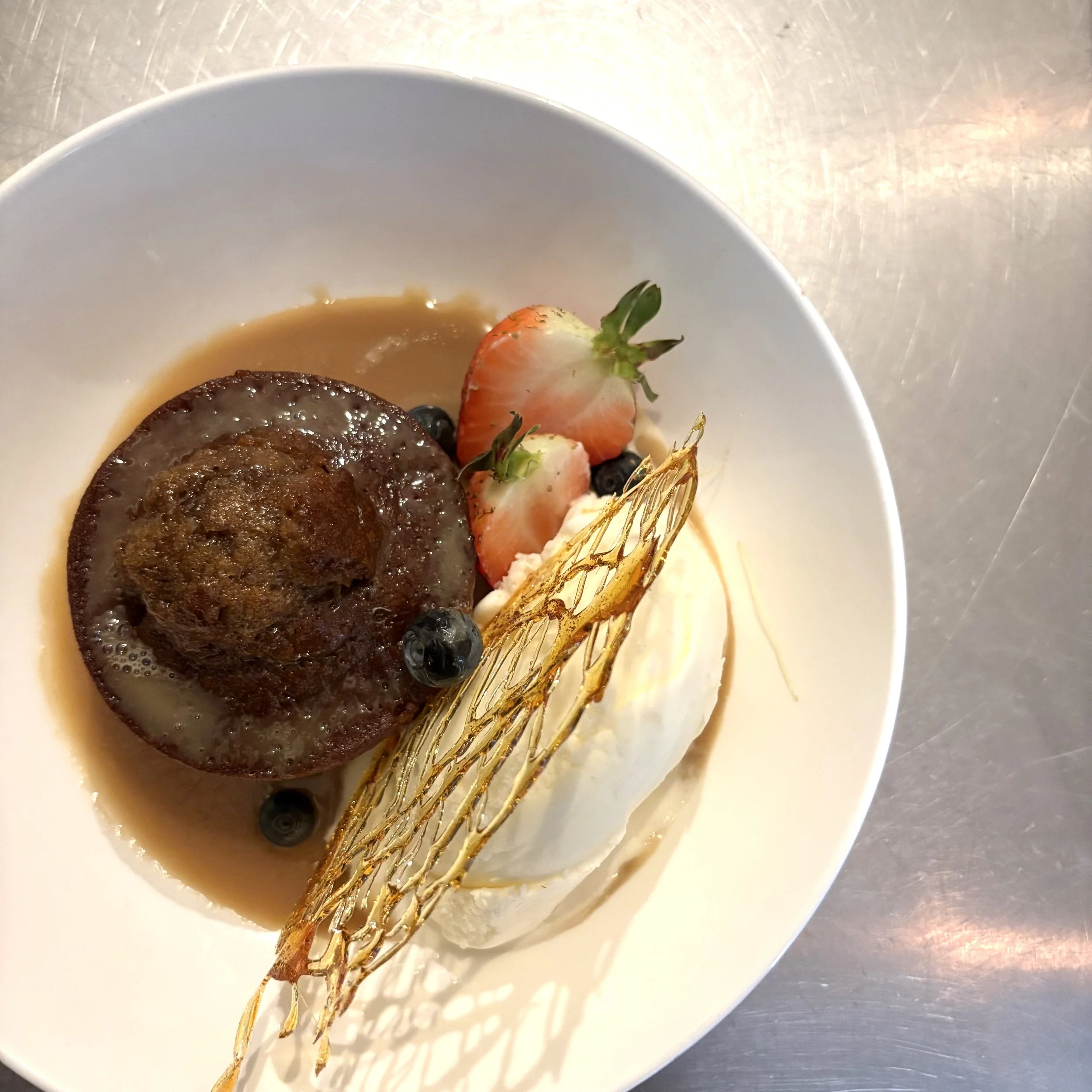 House-made pecan pudding with warm toffee cream sauce, vanilla ice cream, fresh berries, and caramel tuile at Rene’s Bistro in downtown Stratford, Ontario.