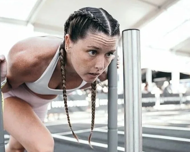 Female athlete with sweat-proof Dutch braids in HYROX competition.