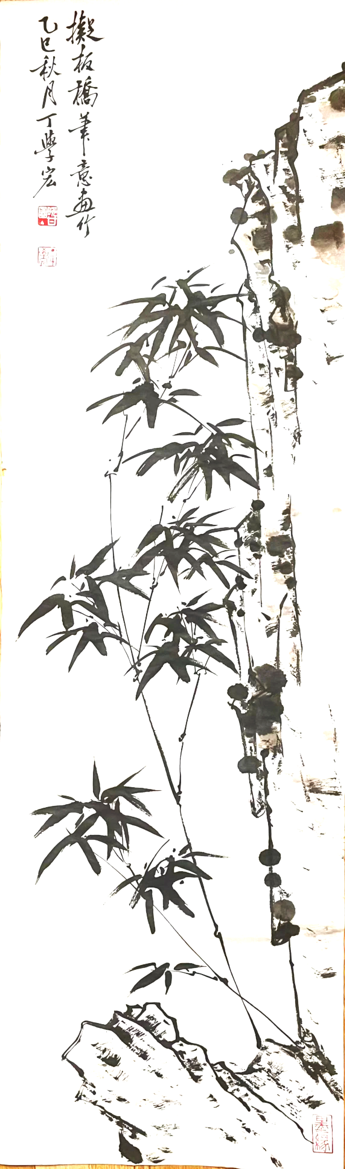 A traditional Chinese ink painting of bamboo plants growing on a rocky surface, accompanied by Chinese calligraphy in the upper left corner.