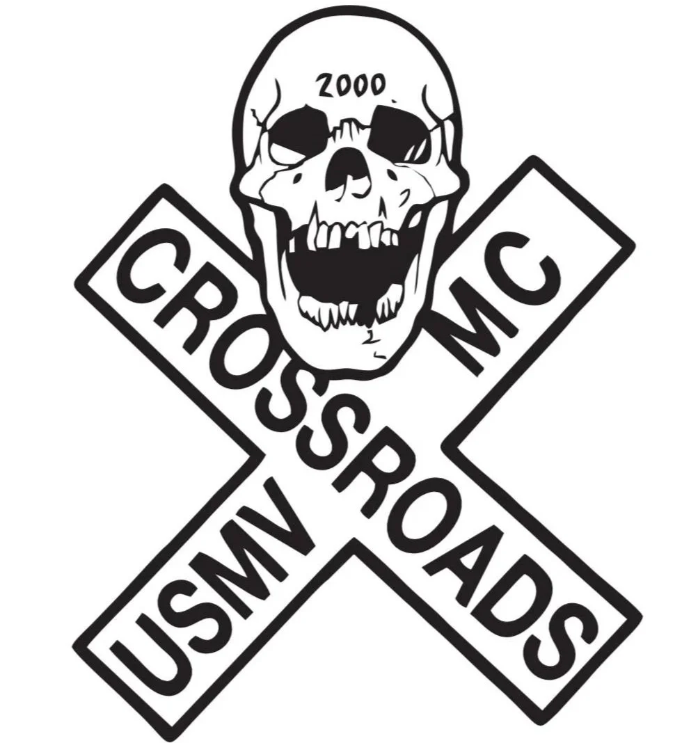 A skull with the word "ZOOO" on its forehead, attached to an American cross sign with the words "CROSSROAD" and "USMC".