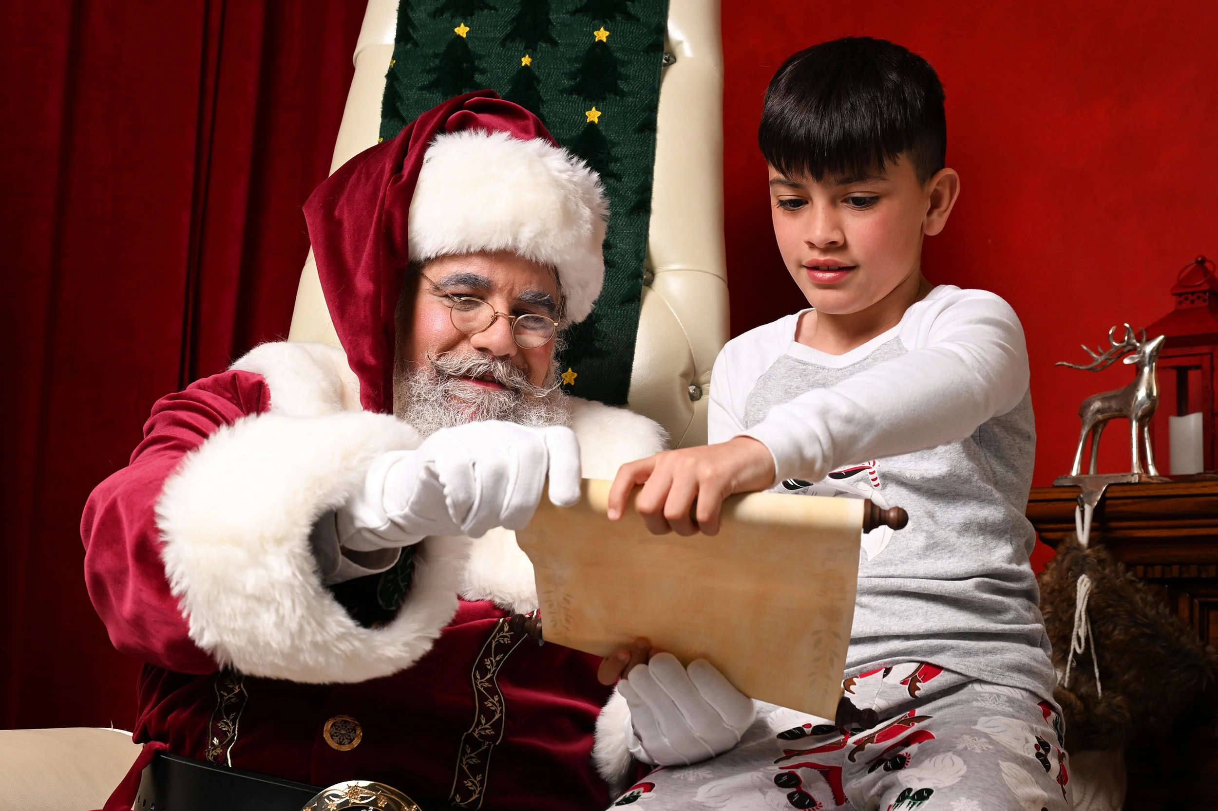 A boy and Santa Claus look over the Nice List.