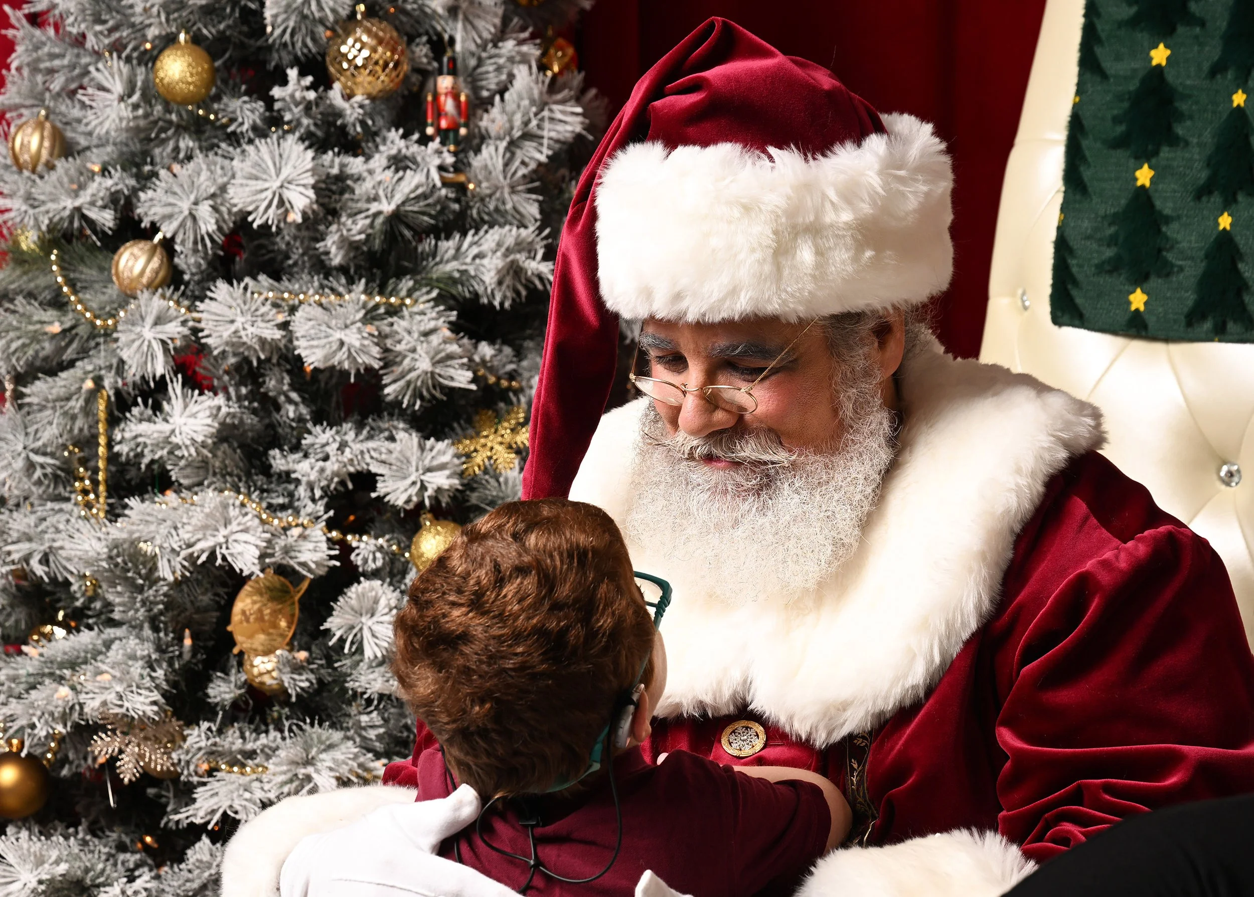 A young boy looks up at Santa Claus.