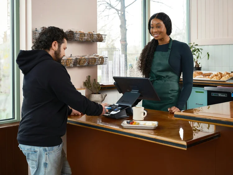 Cafe counter with a customer paying at the register