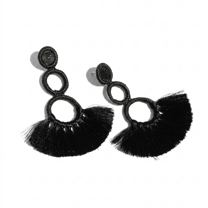 Aretes largos de color negro con detalles de círculos y flecos de hilos.