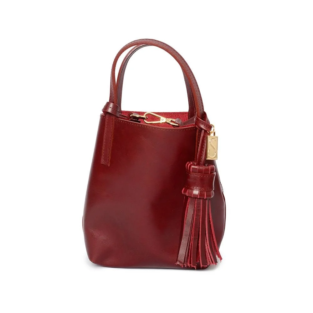 Bolsa de mano de color rojo con borla y detalles dorados