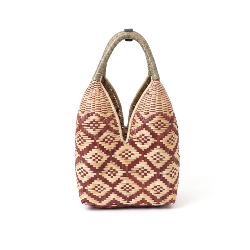 Bolso de mimbre con diseño geométrico en tonos beige y marrón, con asas de material similar y apertura superior.