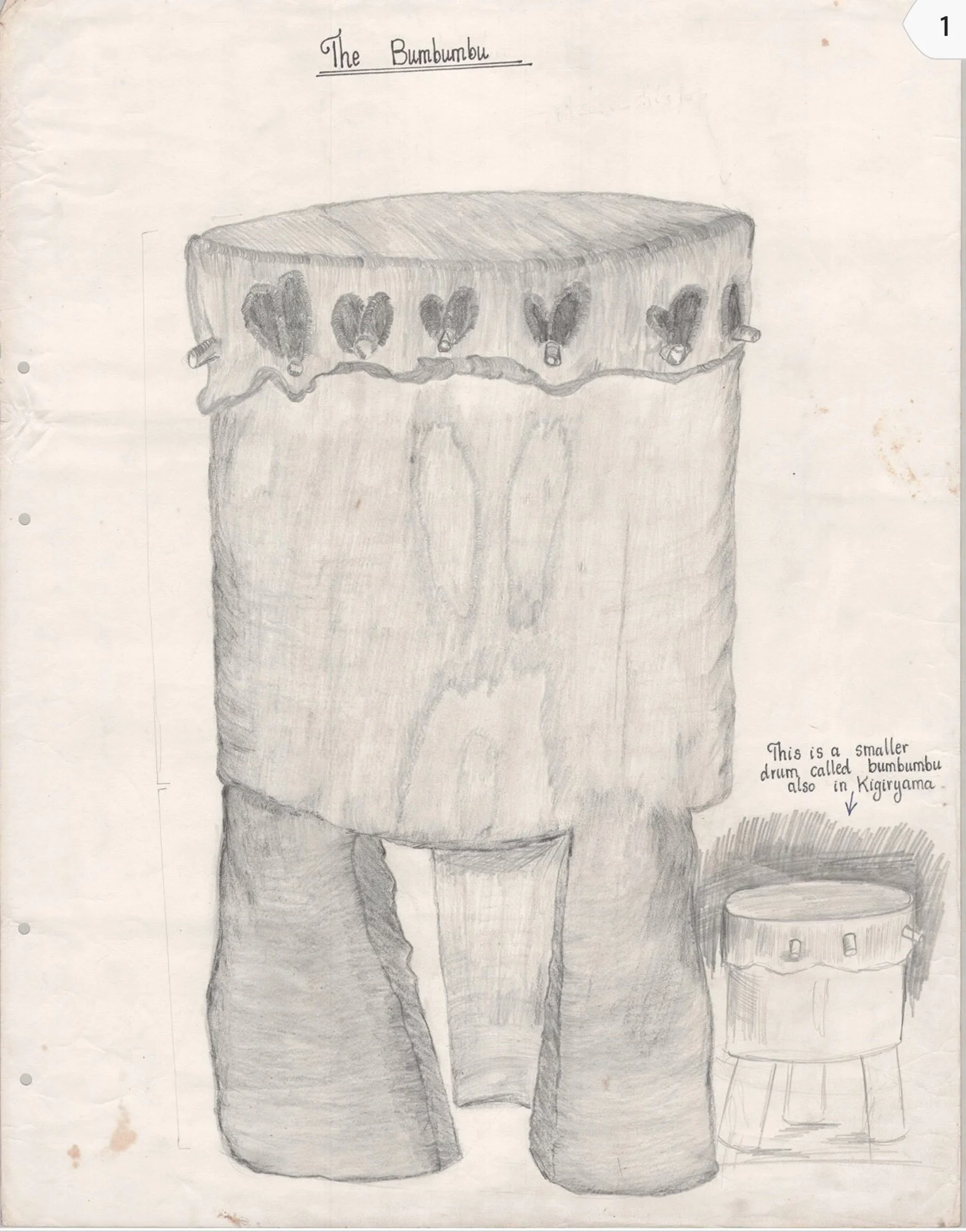 A pencil sketch of a large drum called a Bumbumbu with heart-shaped symbols around its middle, and a small drum called a Kijiruyama to the right of it. There is also a note pointing to the small drum that says, 'This is a smaller drum called bumbumbu