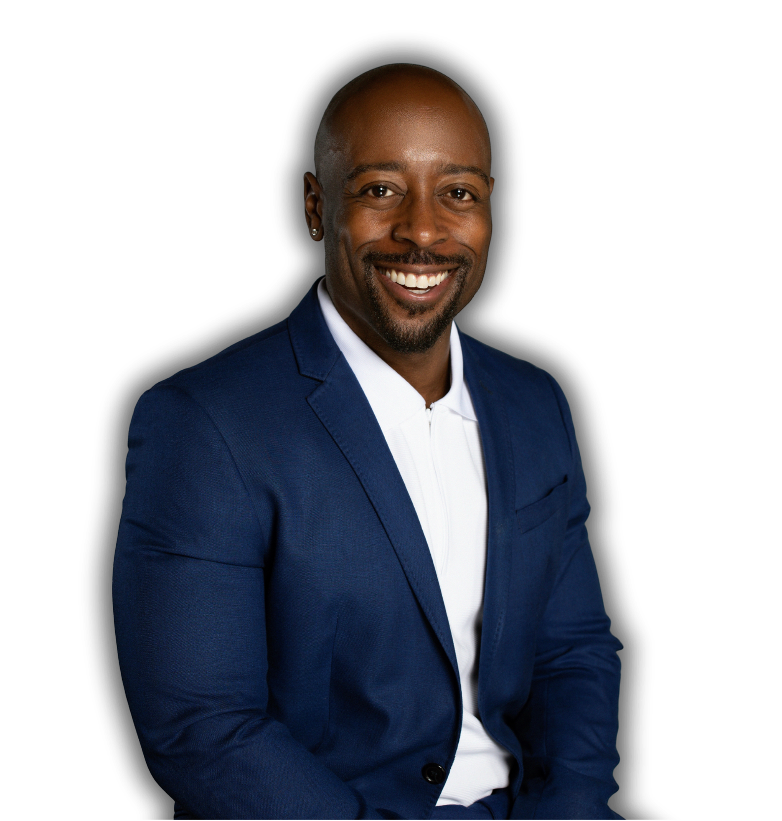 Headshot of smiling African American man with a beard, short hair, wearing a blue suit jacket over a white shirt, posing against a black background.