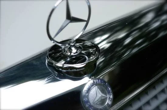 Close-up of a Mercedes-Benz hood ornament and emblem on a black car