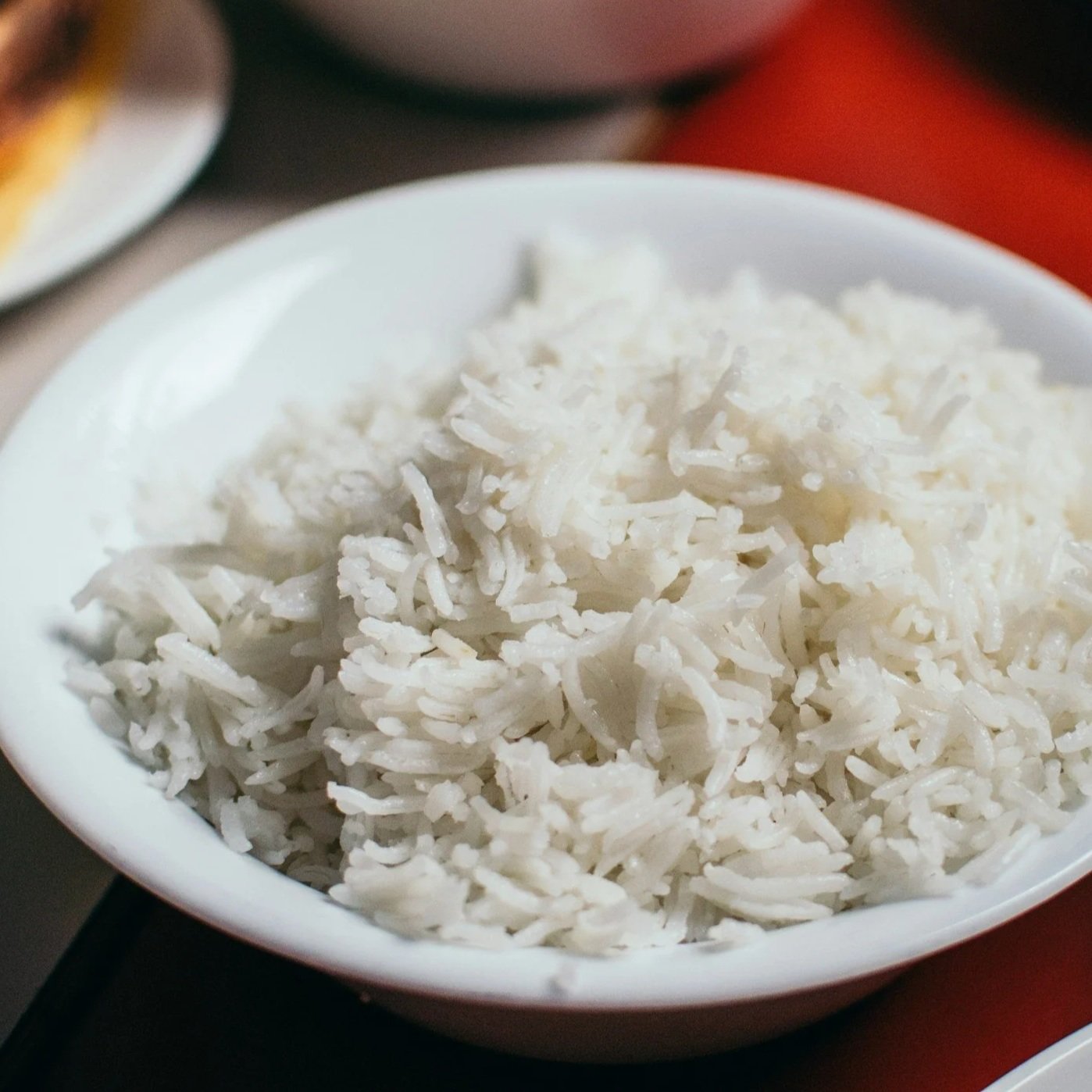 Bowl of cooked white rice on a table.
