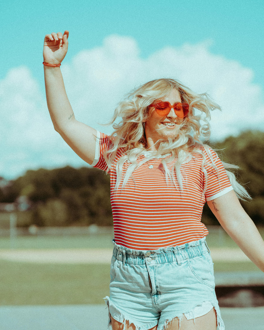 Whitney, founder of Wyld Sol Body Sugaring, smiling outdoors in Calgary, Alberta, celebrating confidence, self-care, and authentic beauty.