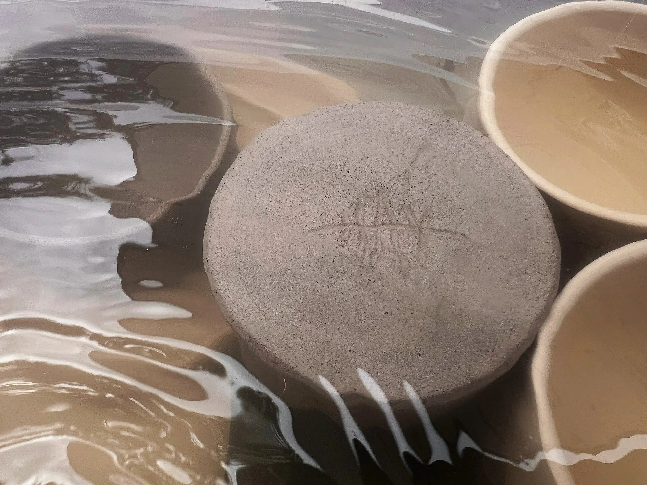 Close-up of a smooth, round stone surrounded by flowing water with white foam. Legally owned photo: Vibeke Hay Wold