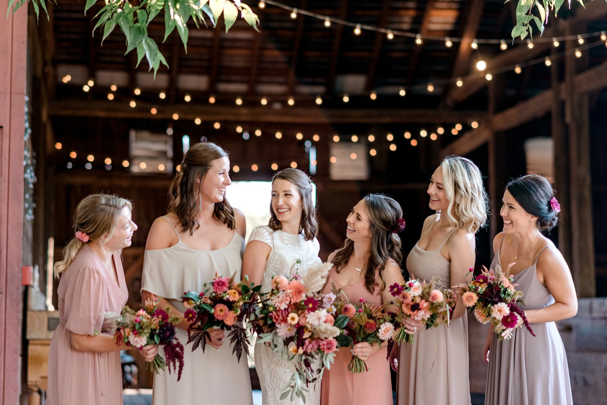 A group of bridesmaids dressed in pink and neutral-colored dresses  at Rocklands Farm Winery for a wedding