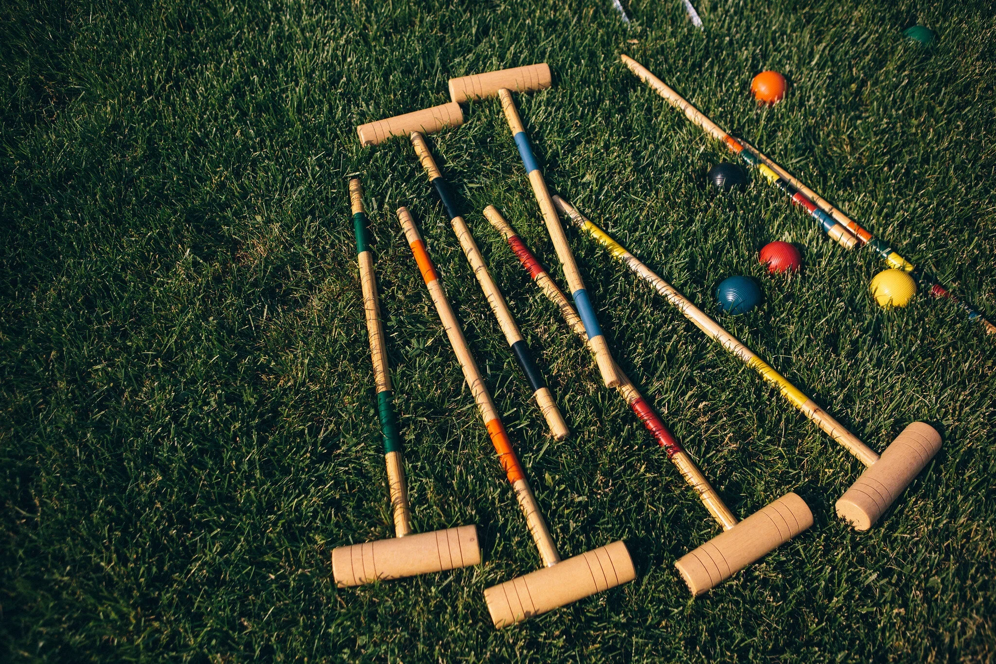Croquet mallets and balls scattered on grass at Rocklands Farm Winery