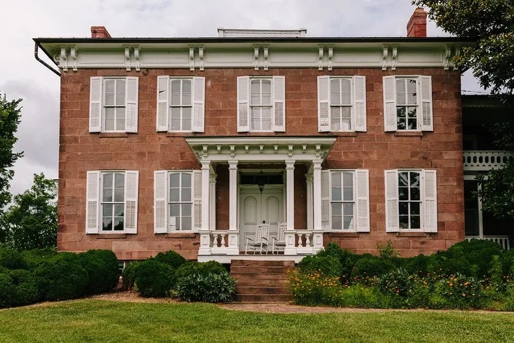 A two-story brick house with white shutters at Rocklands Farm Winery