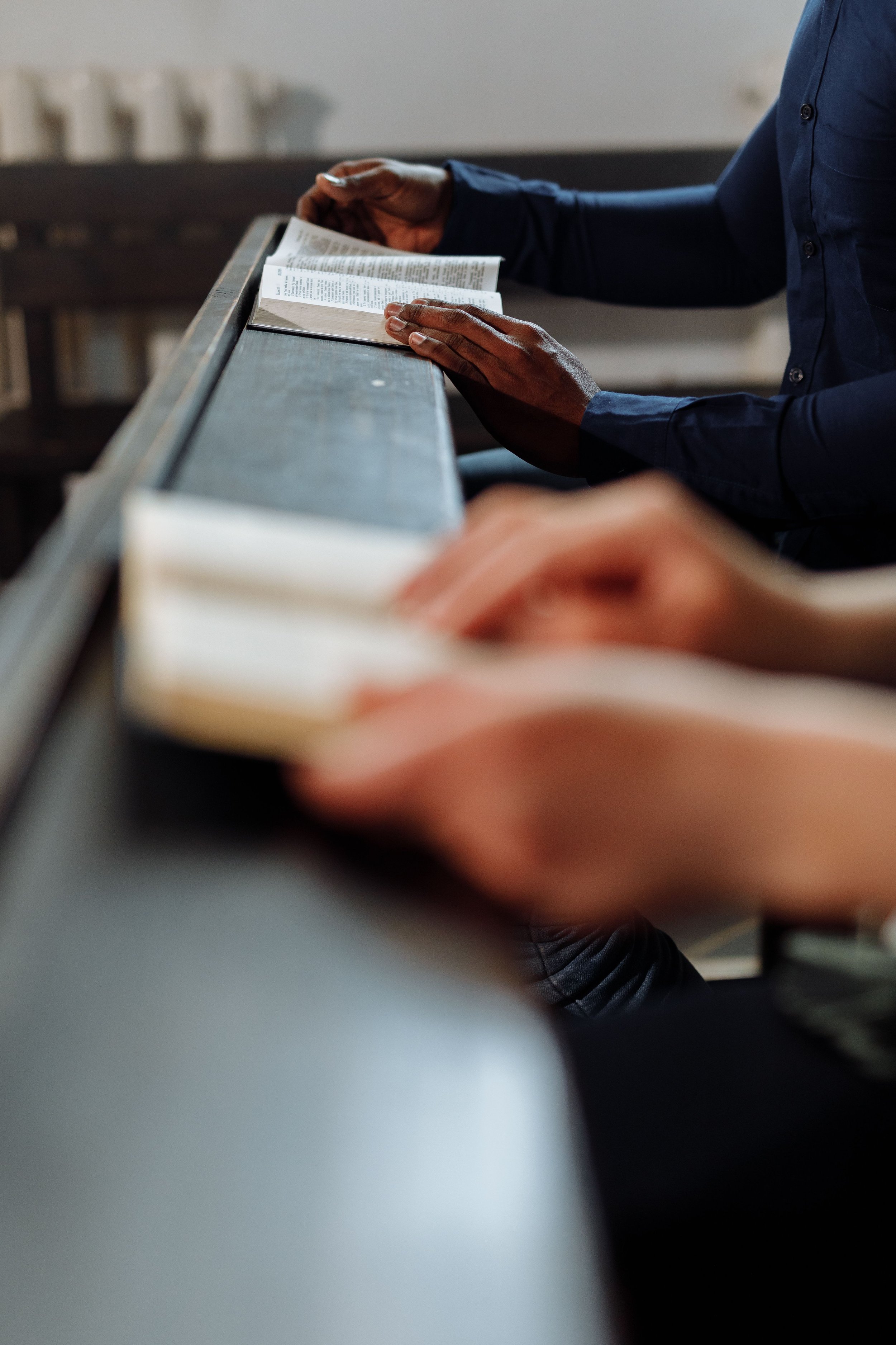 Person reading a book while sitting at a desk.