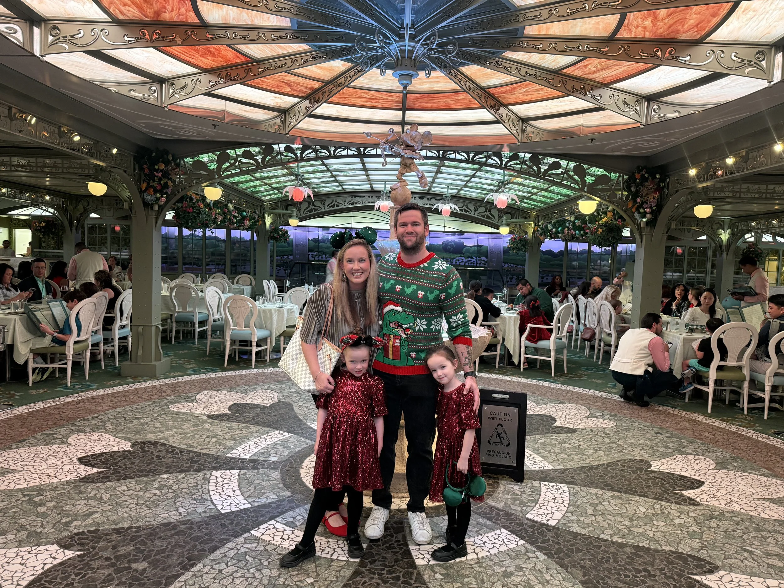 Matt and Kathleen Spearman with their two daughters in the Grand Hall of the Disney Dream, dressed in holiday clothes at Christmas