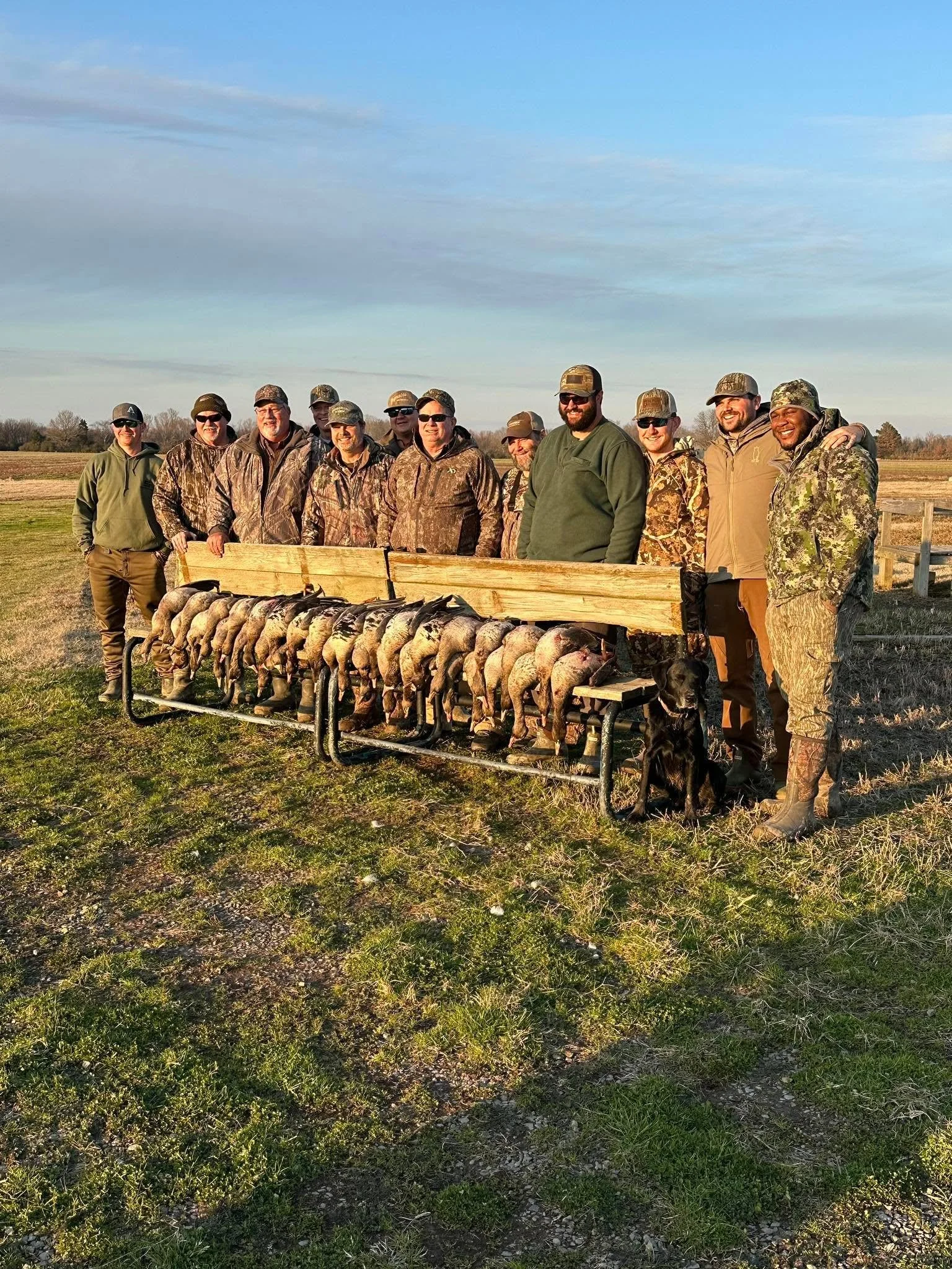 Group of people dressed in camouflage and outdoor clothing after a guided goose hunt