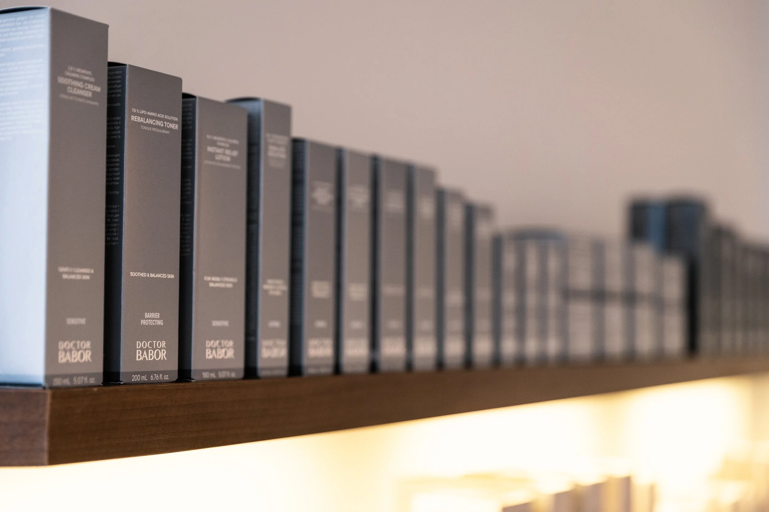 Bücherschrank mit schwarzen Kosmetik- oder Hautpflegeprodukten auf einem Holzregal
