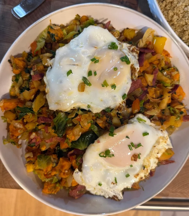 Sweet potato bacon breakfast hash topped with two eggs