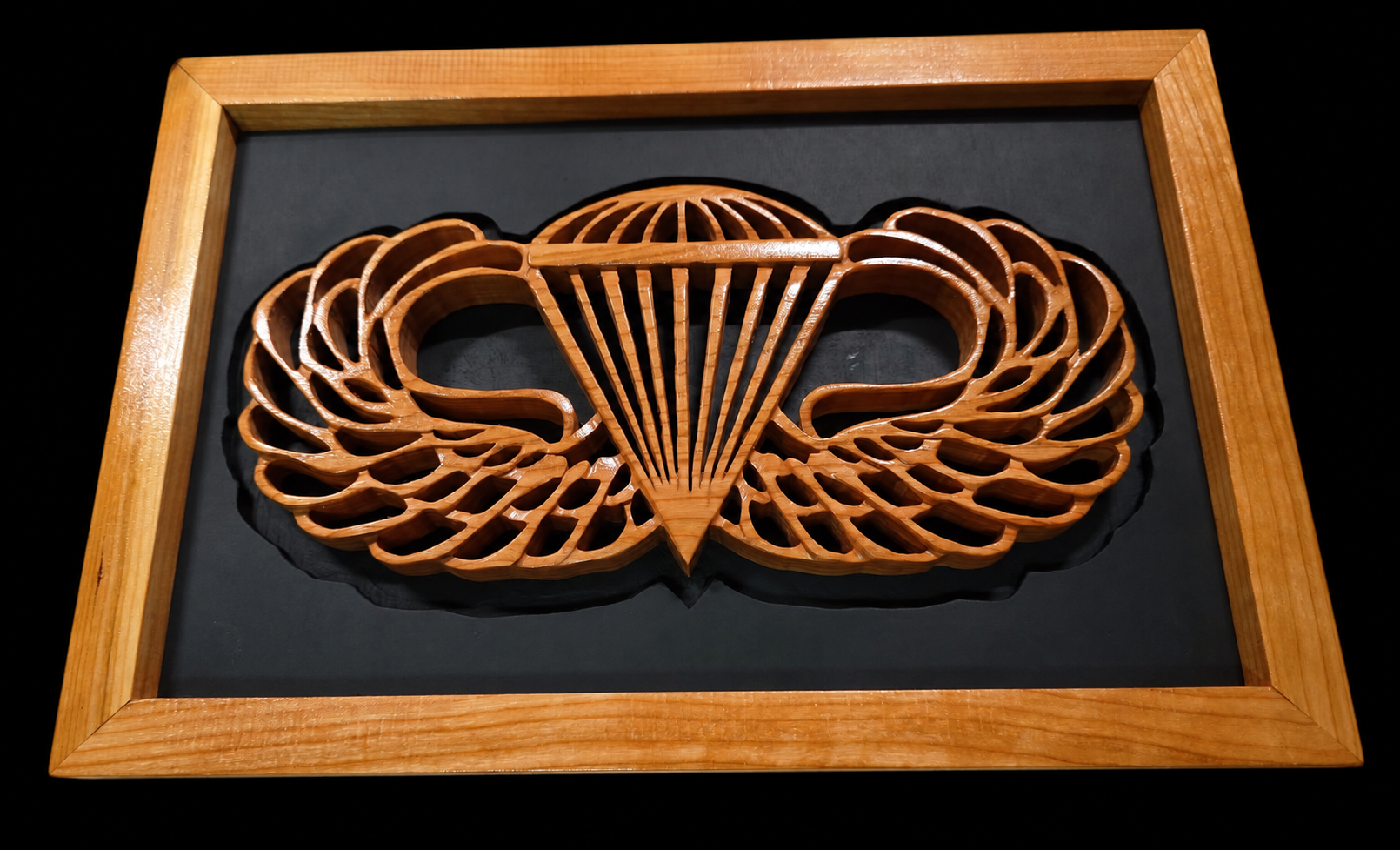 Cherry hardwood Army Airborne wings with detailed scrollwork, mounted on a black backer in a matching cherry frame.