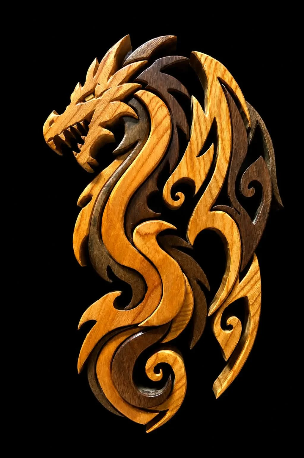 Wooden carving of a dragon's head and body with intricate swirling patterns on a black background.