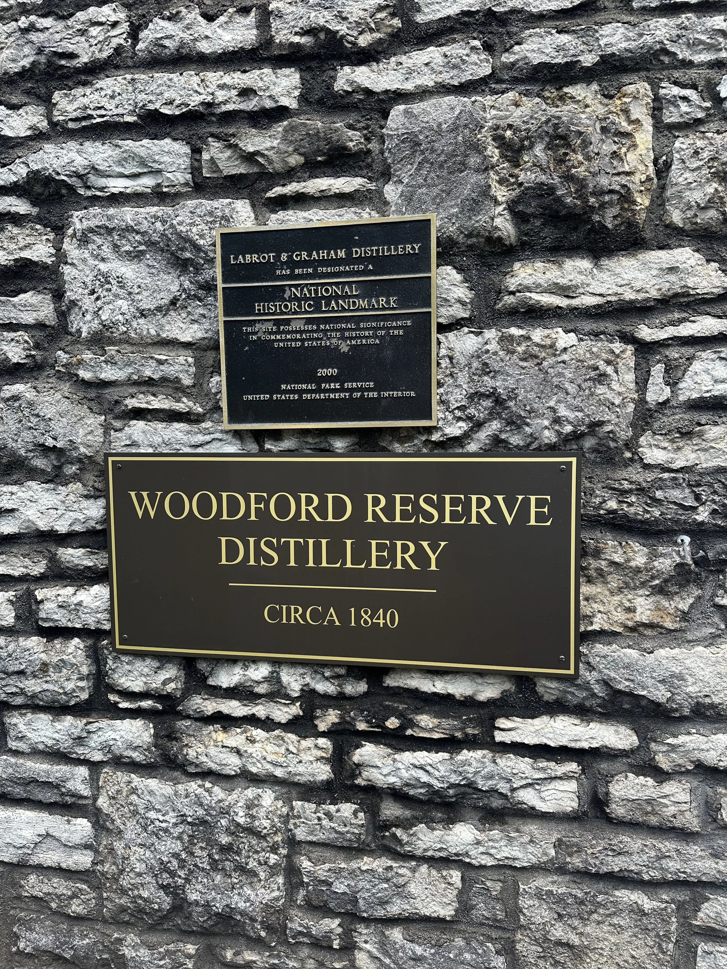 A sign on a stone wall for the Woodford Reserve Distillery, Circa 1840.