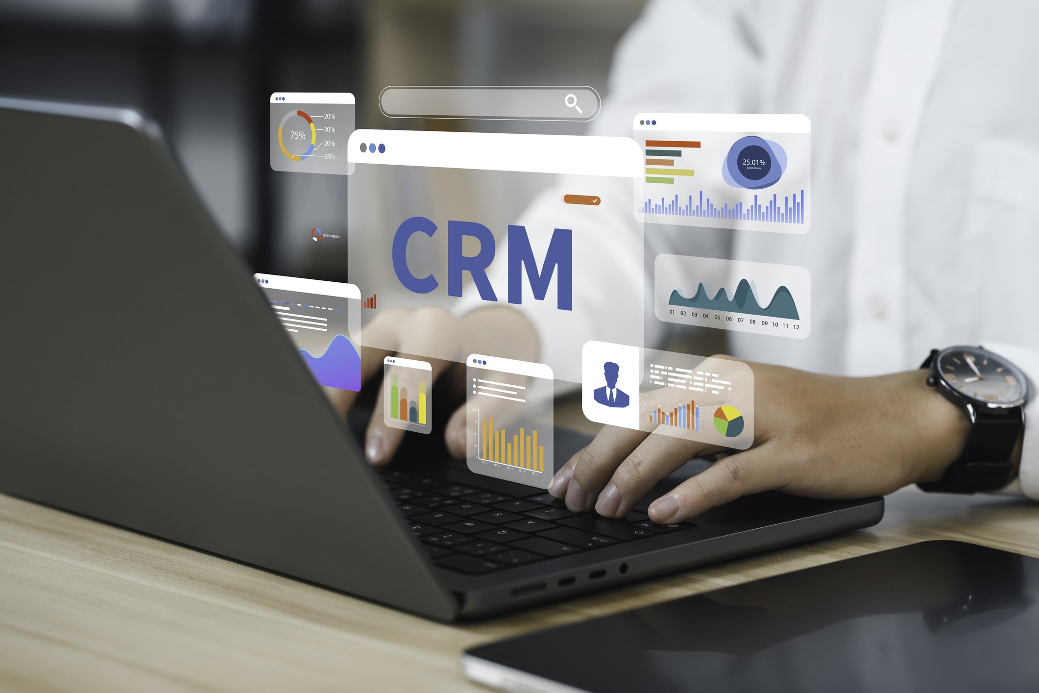 Business owner using a laptop with a CRM system and digital reporting tools.